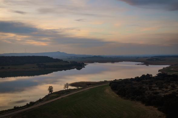 View from a high vantage point overlooking a swamp and surrounding fields. The photograph was taken in the last light of the sunset.