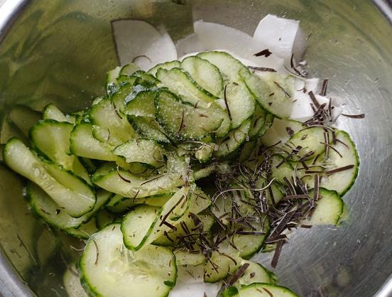 In dünne Scheiben geschnittene Gurke und Mairüben sowie klein geschnittener Kombu in einer Schüssel