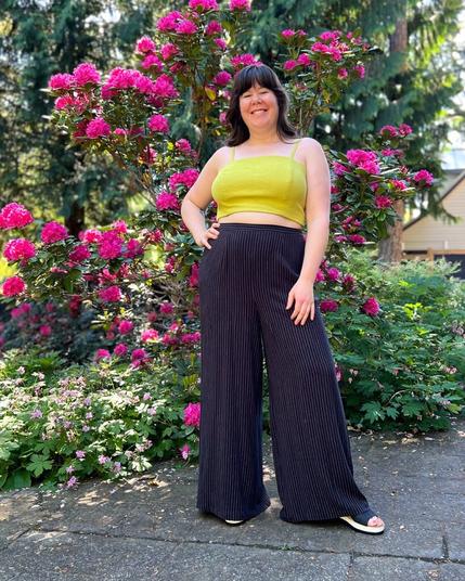Helen wears flowy wide-leg pinstripe trousers with a yellow crop top.