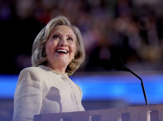 photo of Hillary Clinton in a crowd of  looking above at the harpies that have come to eat her as a snack