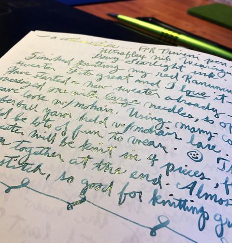 Open page of a journal written in flowy fountain pen cursive. Ink is greenish blue like the ocean, with a green shimmer when viewed at a certain angle.