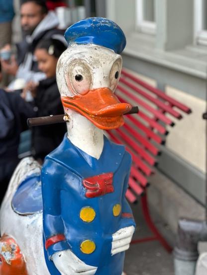 A children’s ride shaped like Donald Duck, only worn and grimy, particularly around the eyes, which appear to be fixed in an unsettling stare