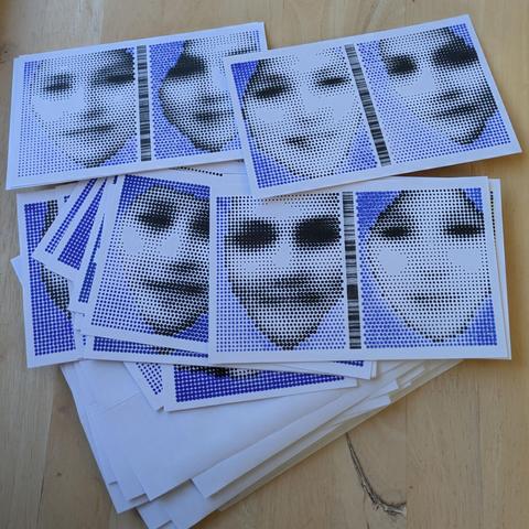 A set of plotted postcards in black and blue, each consisting of two faces rendered in halftone with a barcode between them