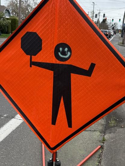 Construction worker sign, spray painted to have a happy face.