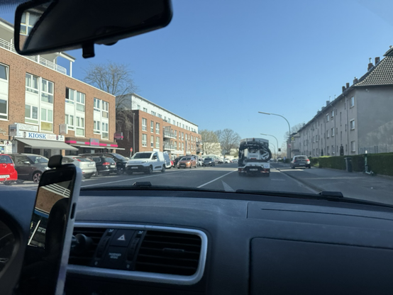 Blick aus dem Cockpit auf eines Autos auf die Strasse.