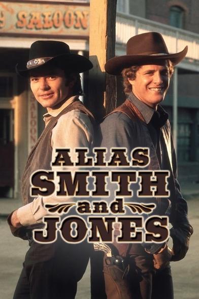 Two men in cowboy attire stand side by side in a Western setting, with a saloon in the background. The title "Alias Smith and Jones" is prominently featured at the bottom.