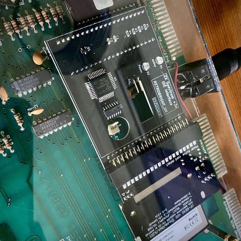A picture showing the IDE interface in more detail. It has taken the place of the Z80 processor. The adaptor sits in the old DIP socket and extends to the right, where the floppy drive would normally be mounted, but in this system has been removed. A CF card is attached. Instead of the original DIP Z80, this board has a surface mounted QFP variant (which is much smaller). Not quite in shot is one of the two EPROMs which have replaced the original mask ROMs.