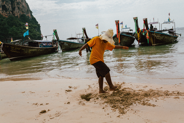 Person kicking sand on Railay Beach in Thailand.