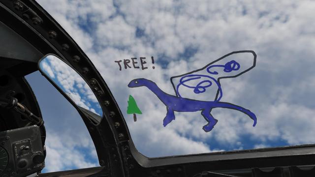 Screenshot from DCS, where a blue dragon has been drawn on the canopy of a jet - shouting out a warning about a tree! A small tree is drawn next to them