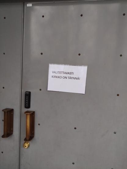 Kirkon ovessa lappu: "VALITETTTAVASTI KIRKKO ON TÄYNNÄ"