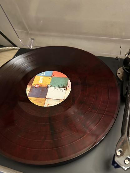 The vinyl, plum/red coloured waiting to be played on the record player.