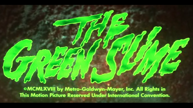 The words The Green Slime in fluorescent green on a  metereoid background. The intro frame of American science-fiction movie The Green Slime from 1968, directed by Kinji Fukasaku.