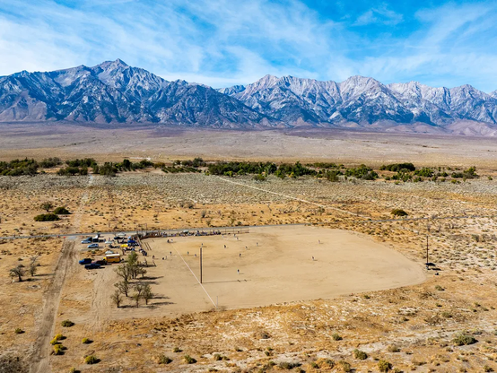 Image of a baseball field in the middle of the Sierra Nevada region of California, with mountains looming in the background.