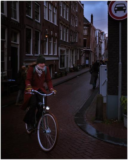 A person riding a bicycle. And there’s a symbol of cars not allowed.