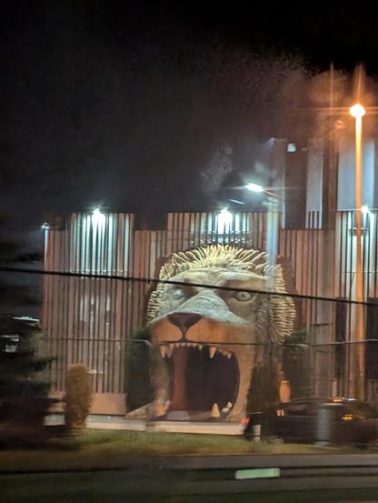 A shot from a car, showing a night club entrance shaped as a gaping mouth jaw