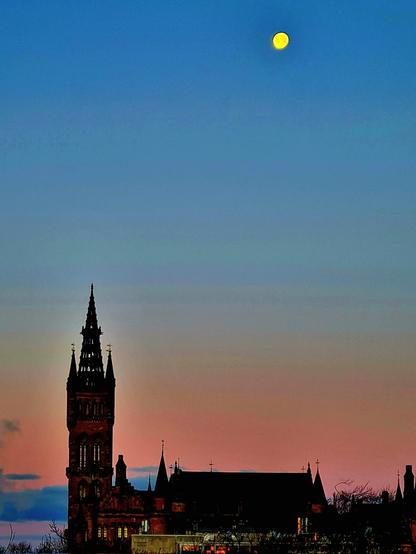 The moon setting behind Glasgow University's main tower just as the sun is rising.