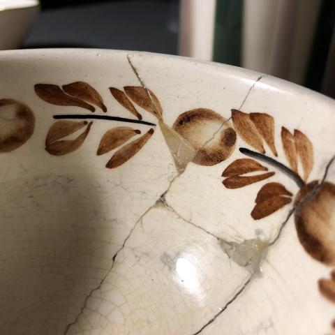 A bowl glued back together, photo focusing on smoothly filled-in gaps, not in gold yet.