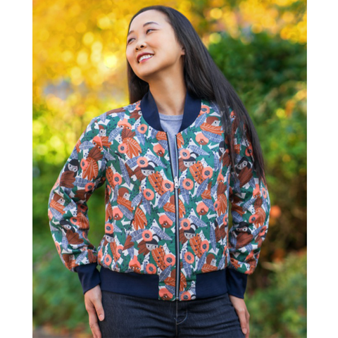 A floral bomber jacket with deep blue ribbing at the neck, cuffs, and hem.
