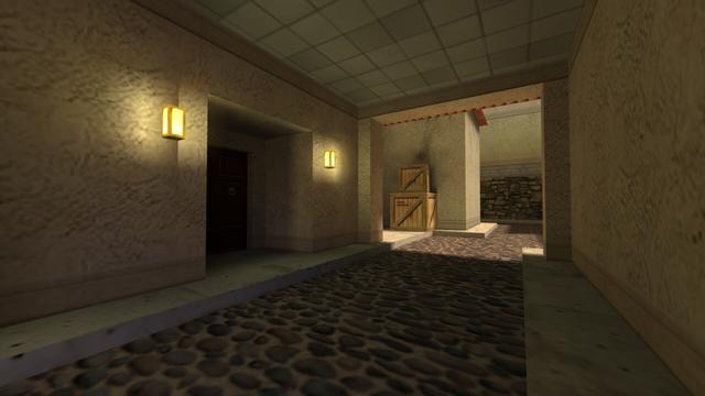 In this picture you can see a small underpass, which is below and behind the position from the previous picture. This leads to an alley. In addition, you can see an entrance on the left with a dark brown wooden door. To the left and right of this is a yellow-lit lamp attached to the wall. If you look through the underpass, you can see a small wooden box standing on top of a large wooden box. Behind it is a house and next to it a path that leads behind the house. This is on the map cs_italy in the game Counter-Strike 1.6.