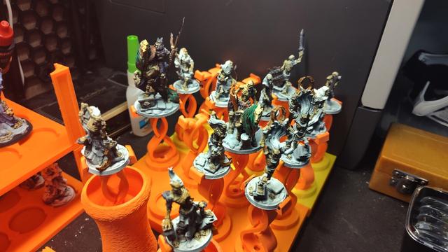 Arbiter Miniatures Legion of the Undead models primed and in progress of being painted, set up in model painting holders drying for the next color.