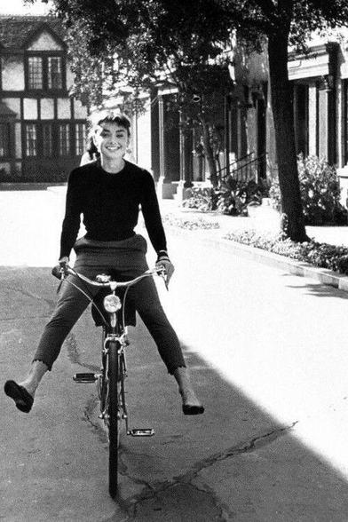 Audrey Hepburn montando feliz en una bicicleta
