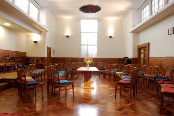 Picture of Westminster Quaker Meeting Room - Table with flowers in centre surrounded be concentric circles of chairs. Bathed in sunlight