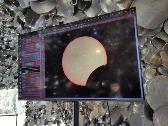 Eclipse solaire du 29 mars 2025 vue de Meudon au hangar Y. L'observatoire de Paris avait installé un telescope muni d'un filtre et d'une camera, pour transmettre l'eclipse sur un écran. on y voit le soleil commençant a bien être "mangé" par la lune. de légéères taches solaires sont visibles, ainsi que des protubérances solaires sur le contour de l'astre.