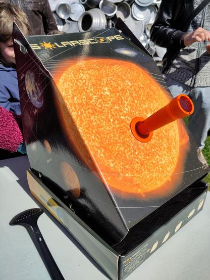 Le "solarscope" qui permet de  regarder l'eclipse sans danger en projetant le soleil pointé par la lentille du tube rouge dans le fond de la boite (de l'autre coté).