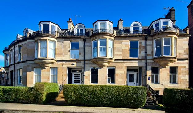 A terrace of Victorian era blonde sandstone Glasgow townhouses.
