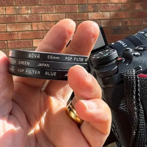 I’m holding my Hoya ‘Pop Filter’ set of three circular (55mm thread) red blue and green glass filters (with the Nikon Z30 and 50-250mm lens behind it