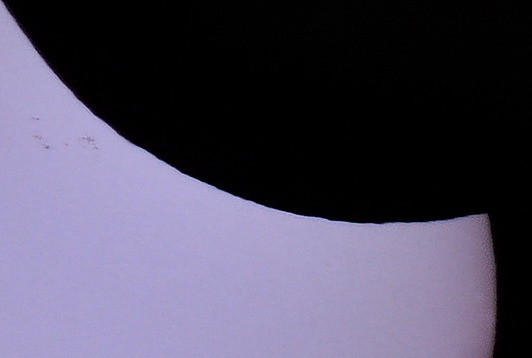 Ausschnittsvergrößerung der Sonnenfinsternis. Der Mondrand erscheint leicht zackelig.
