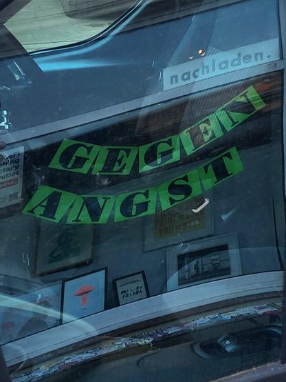 Sich spiegelnd auf grünem Papier in schwarzen Lettern: 
GEGEN 
ANGST