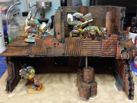 Two storeys of scrap (corrugated iron, barrels, metal beams) shanty with some angry orks in