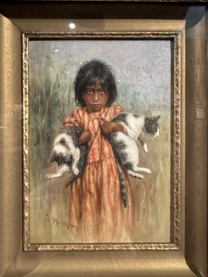 photo of the painting in gold frame on display at museum portrait of a native Hawaiian child in red and yellow striped clothing holding two grey and white cats (one under each arm) outdoors amongst tall grasses