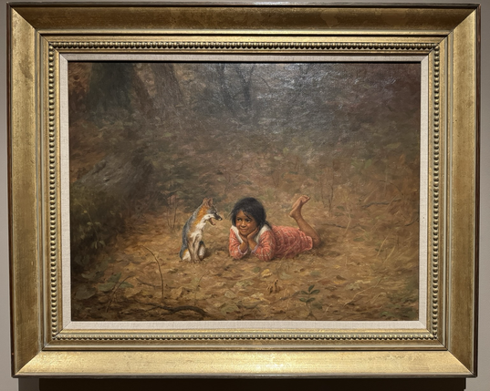photo of the painting in gold frame on display at museum Portrait in landscape orientation of a young Pomo girl and her pet fox sitting together on the forest floor