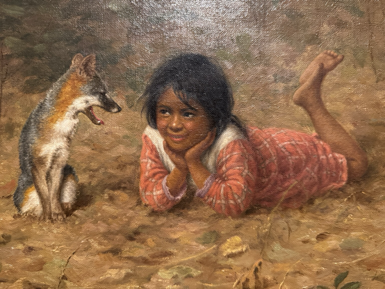 closeup of the fox and girl: fox sitting up looking at girl with happy face, girl in pink and white checkered dress on stomach propped up on elbows with hands under chin and with legs up in the air, looking at fox smiling back