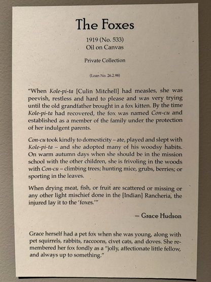 photo of gallery label: The Foxes 1919 (No. 533) Oil on Canvas Private Collection (Loan No. 26.2.98) "When Kole-pi-ta [Culin Mitchell] had measles, she was peevish, restless and hard to please and was very trying until the old grandfather brought in a fox kitten. By the time Kole-pi-ta had recovered, the fox was named Con-cu and established as a member of the family under the protection of her indulgent parents. Con-cu took kindly to domesticity - ate, played and slept with Kole-pi-ta - and she adopted many of his woodsy habits. On warm autumn days when she should be in the mission school with the other children, she is frivoling in the woods with Con-cu - climbing trees; hunting mice, grubs, berries; or sporting in the leaves. When drying meat, fish, or fruit are scattered or missing or any other light mischief done in the [Indian] Rancheria, the injured lay it to the 'foxes!' - Grace Hudson Grace herself had a pet fox when she was young, along with pet squirrels, rabbits, raccoons, civet cats, and doves. She remembered her fox fondly as a "jolly, affectionate little fellow, and always up to something."