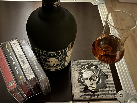 4 Musikkassetten, eine Flasche Rum und ein Stilglas mit Rum