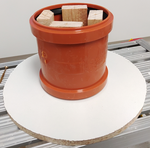 Side wall with wooden blocks mounted and pipe sleeve placed on it. The sleeve has protrusions on both ends (for the O-ring seals) which makes the surface a bit uneven but that's OK.