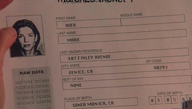 A printout from the Department of Motor Vehicles showing a driver’s license info page with a photograph of a woman with brown hair. The name on the file is Ruth Marx.