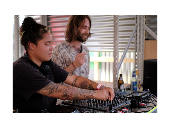 young woman and man standings in uniquely designed dj booth, having obviously fun playing music