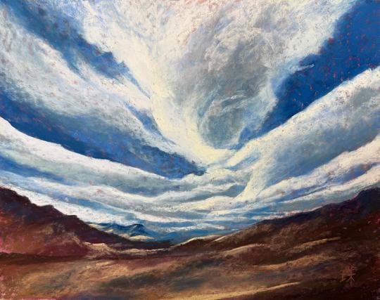 A stylized clouds in very blue sky over high desert mountains.