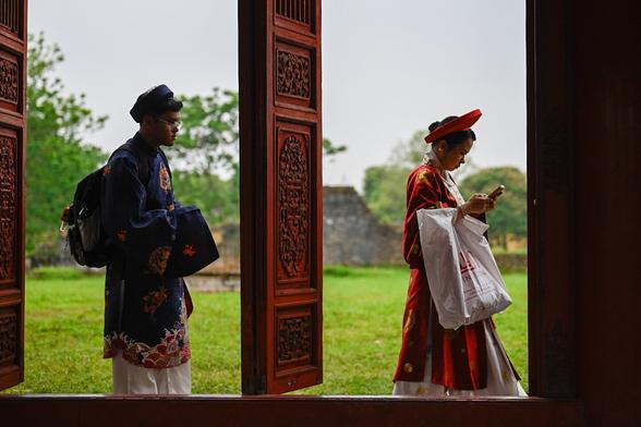 a costumed couple passing by the Imperial City to take wedding pictures