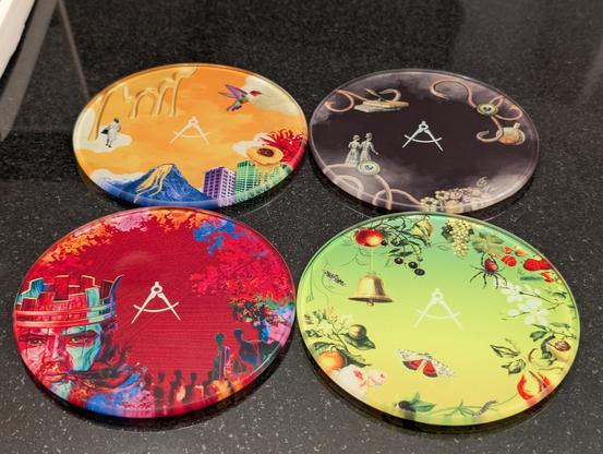 Photo of the four coasters with bottle art - Nectarosity, Crimson Casks, Orchard House, and The Peat Monster.