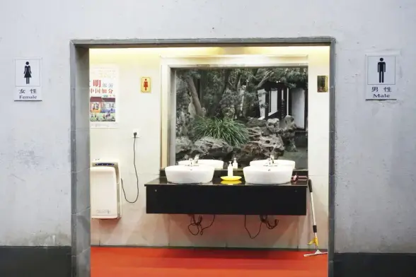 Öffenliche Toilette in Korea. Im Vordergrund rechts und links die Piktogramme mit Beschriftung. Im offenen Durchgang sind zwei Waschbecken vor einem sehr großen Spiegel zu sehen. Dadrin ist ein begrünter Innenhof zu sehen.