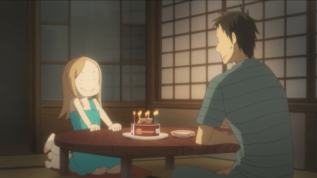 A man (Daikichi) and a little girl (Rin) sit at a low table, the candles of a birthday cake providing the only light in the room. Rin smiles goofily as she leans back and prepares to blow out the candles.