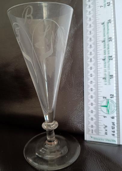 A Georgian 'Short ale' glass. It was made in 3 parts: bowl, stem and foot which were formed separately and then put together. Engraved with barley and hops to show it's use and with the owners initials, BJS. The engraving was done by holding the glass against a rotating abrasive wheel.