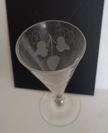 The same glass, photographed from above and against a black background to show the engraved hop flower, leaves and tendrils.
