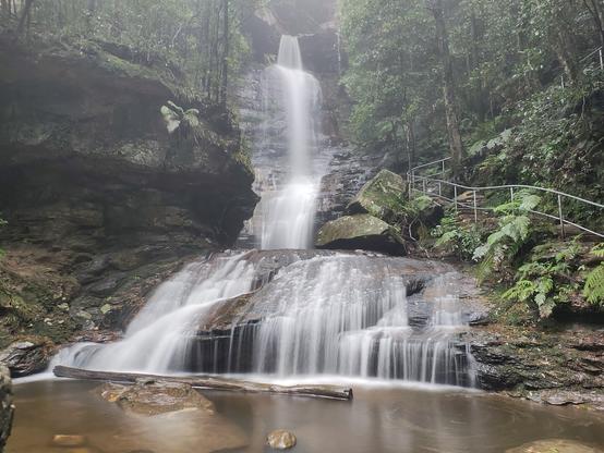 Empress falls long exposure. Water cascading down steep cliffs into a pool surrounded by ferns