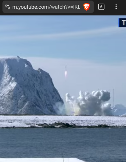 Still from live stream with 'small rocket next to mountain.